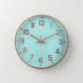 A round wall clock with a light aqua blue face, rose gold numerals and hands, and a rose gold outer rim, shown against a neutral light gray background.