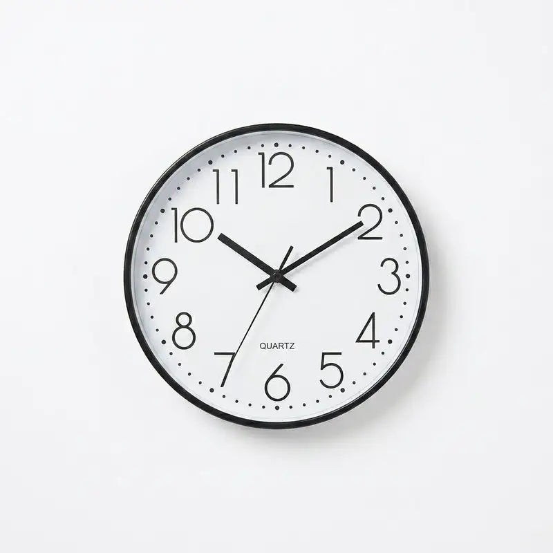 A minimalist quartz wall clock with a black frame, white face, and black numerals and hands.