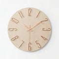 A minimalist round wall clock with a light natural wood face and rose gold metal numerals and hands.